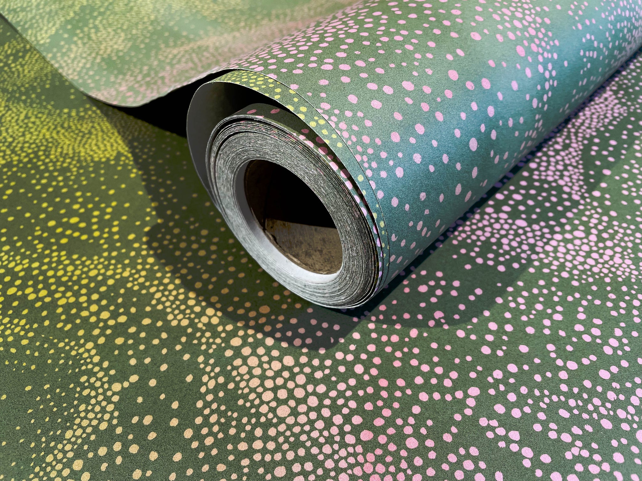 Aurora olive and pink design wallpaper roll close-up by GvE&Co